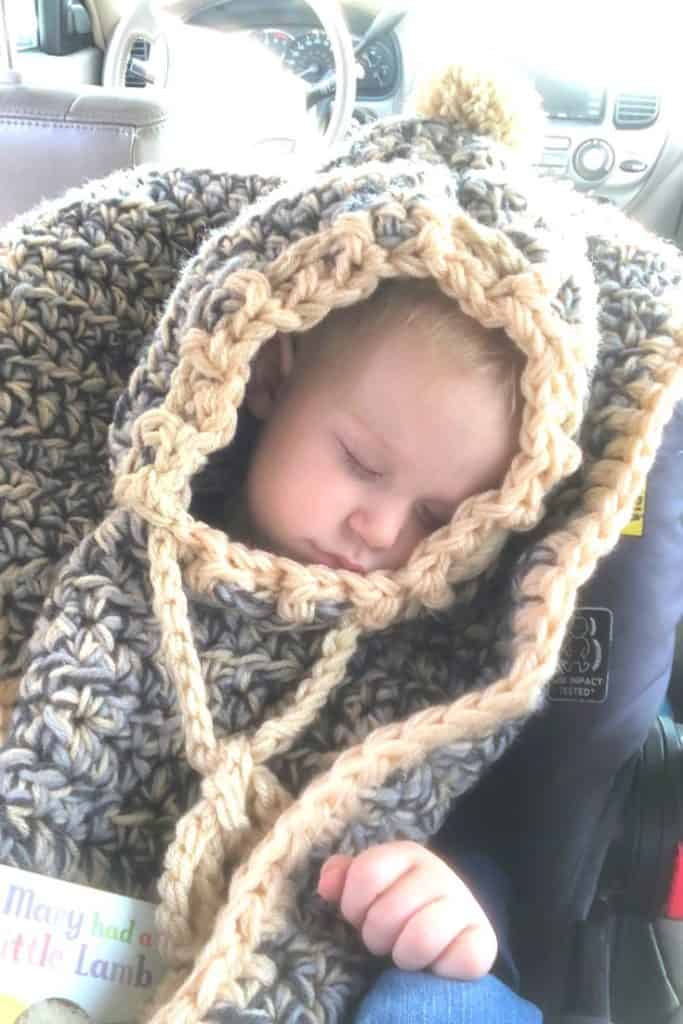 Sleeping in car seat with crochet poncho on