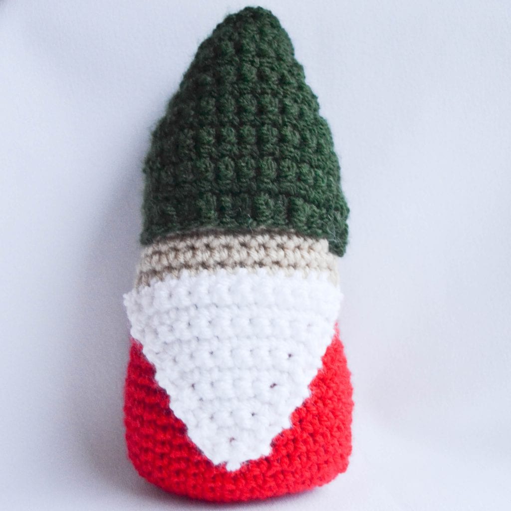 close up of a crochet gnome made with the featured pattern.