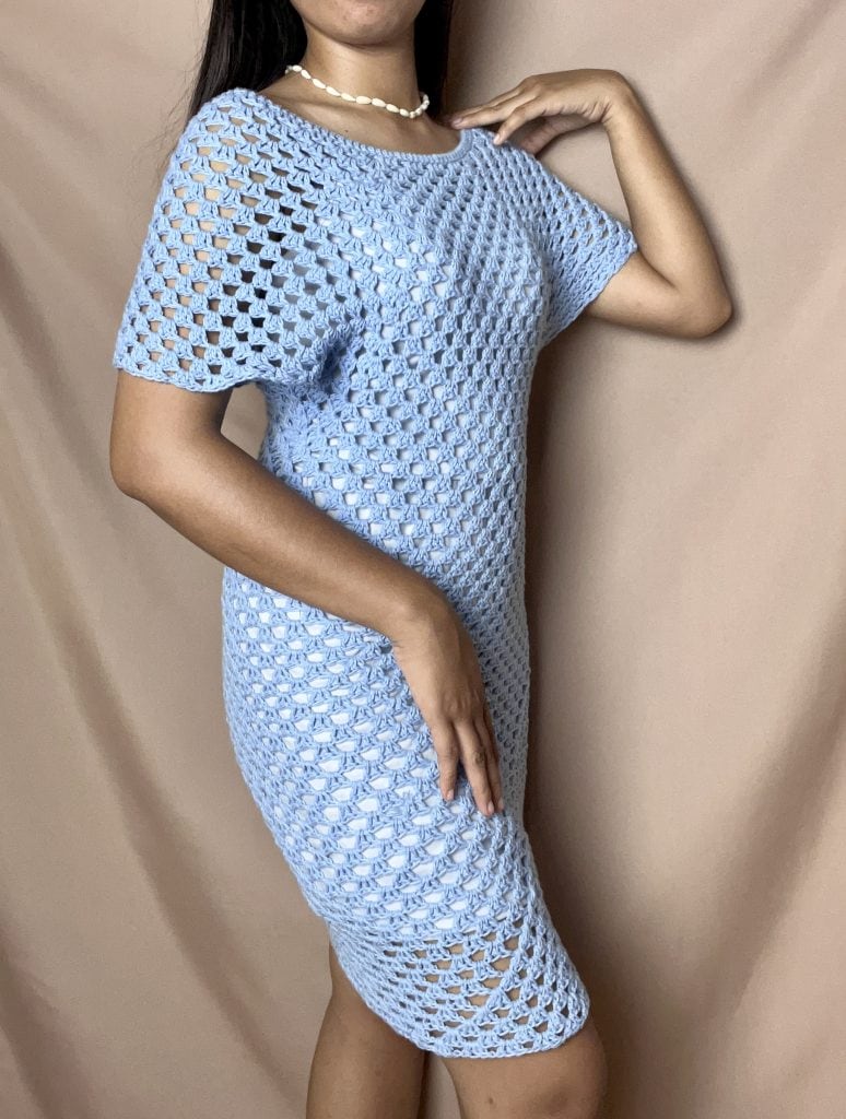 A blue granny stitch short crochet dress being modeled from the side