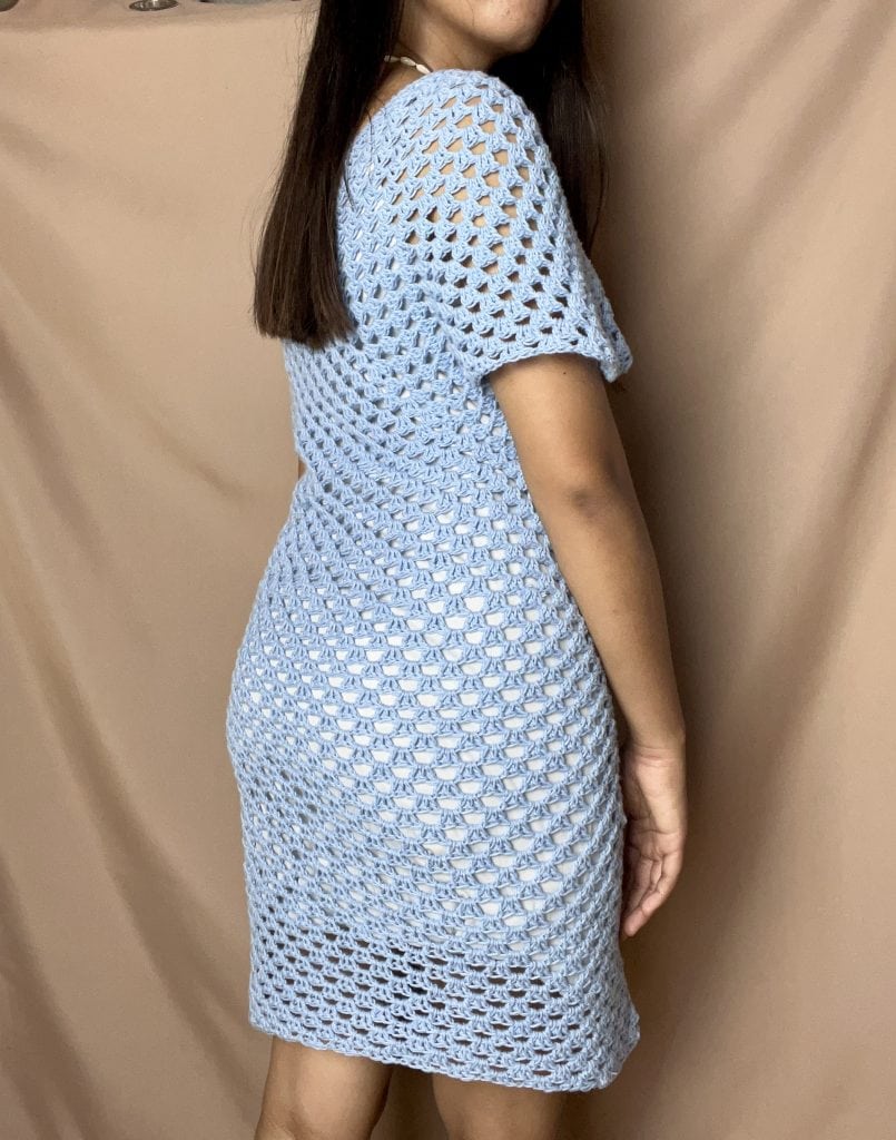 A blue granny stitch short crochet dress being modeled from the back